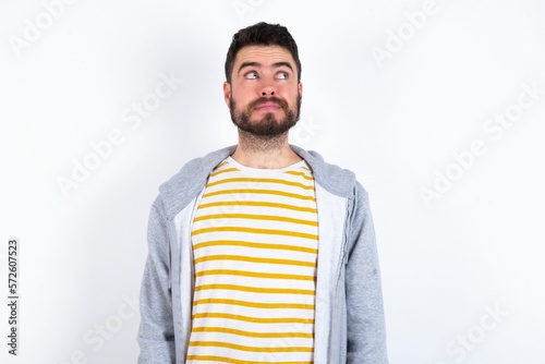 caucasian man wearing casual sportswear over white wall looking aside into empty space thoughtful