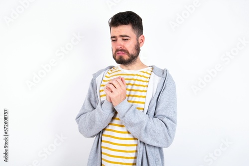 Sad caucasian man wearing casual sportswear over white wall desperate and depressed with tears on her eyes suffering pain and depression in sadness facial expression and emotion concept