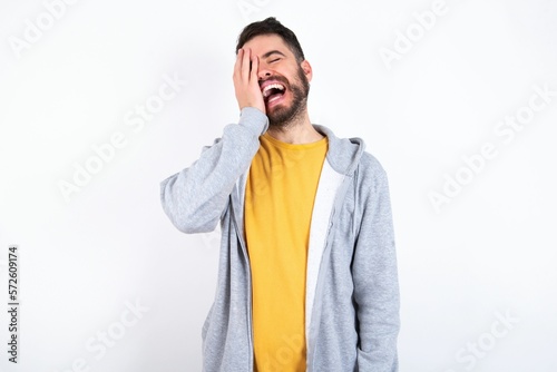 Canvastavla caucasian man wearing casual sportswear over white wall makes face palm and smil