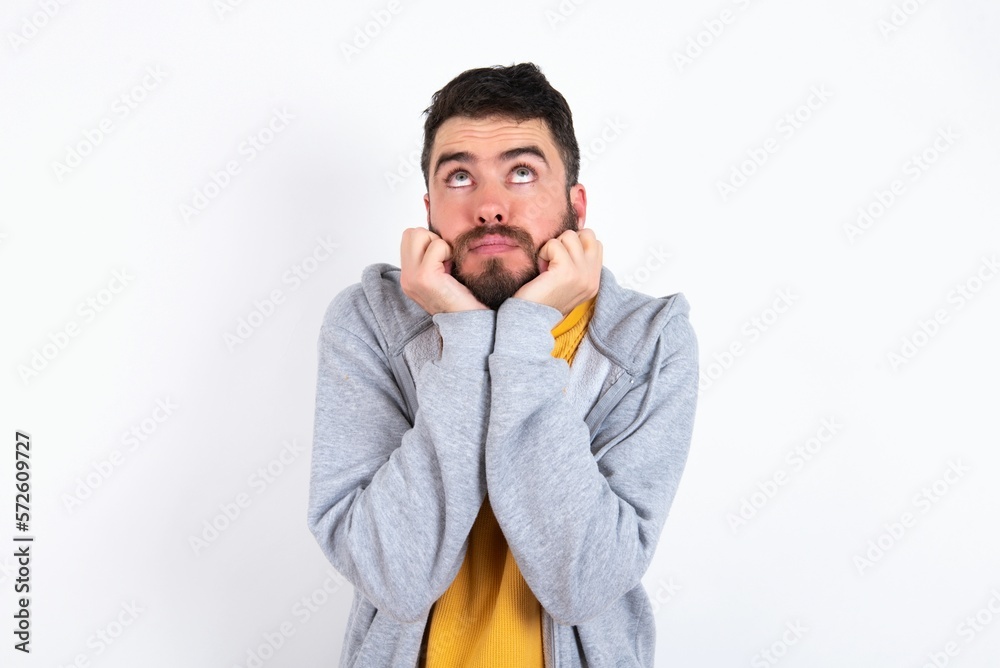 Portrait of sad caucasian man wearing casual sportswear over white wall hands face look empty space Portrait of sad caucasian man wearing casual sportswear over white wall hands face look empty space