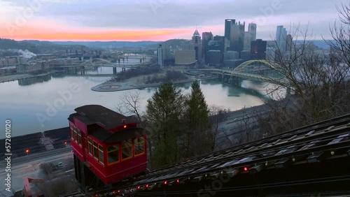 Duquesne Incline car traveling up pulley system. Aerial rising shot of famous tourism location and scenic lookout over Pittsburgh Pennsylvania. Empty trolley car during winter sunrise. photo