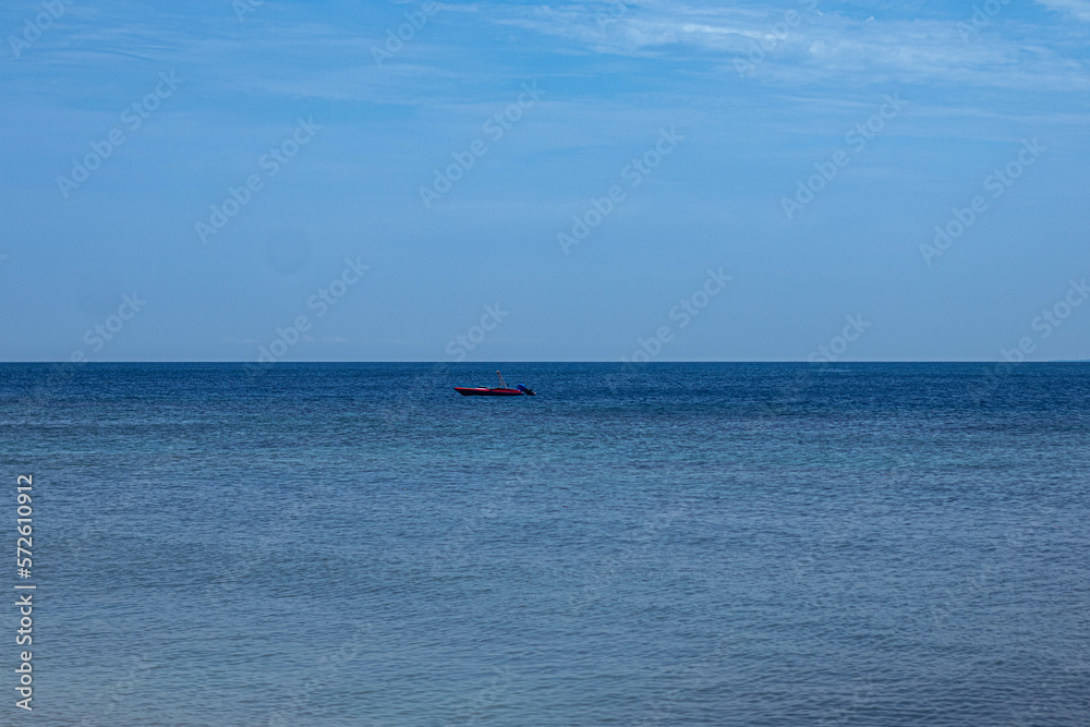 ocean surface and boat with blue horizon indonesia