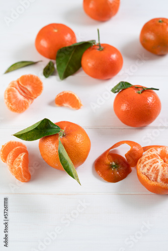 Fresh clementines with leaves on white wooden table.. 