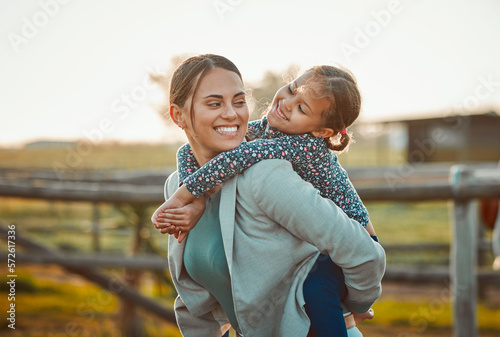 Tela Mother, young girl and hug of a kid piggy back fun and parent care outdoor in equestrian field