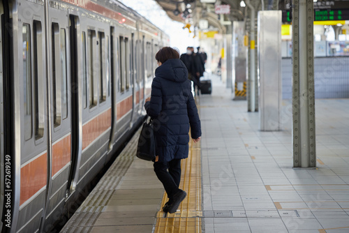 朝のJR名古屋駅のホームで乗車する中高年女性の後ろ姿