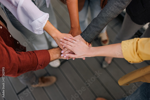Close-up of a successful adult business people joining hands in a corporate meeting.