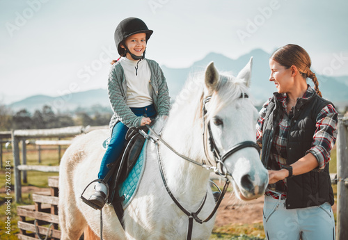 .Happy child on horse, woman with harness on ranch and mountain in background lady and animal walking on field. Countryside lifestyle, rural nature and farm animals, mom girl kid to ride pony in USA.