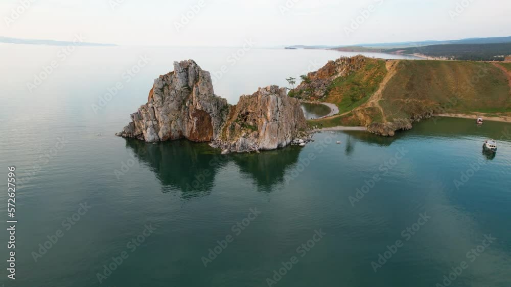 Flight from the drone from Cape Burkhan on the island of Olkhon. There are ships with tourists in the bay near the village of Khuzhir. Lake Baikal on a summer evening. Flight from the drone from Cape Burkhan on the island of Olkhon. There are ships with tourists in the bay near the village of Khuzhir. Lake Baikal on a summer evening.