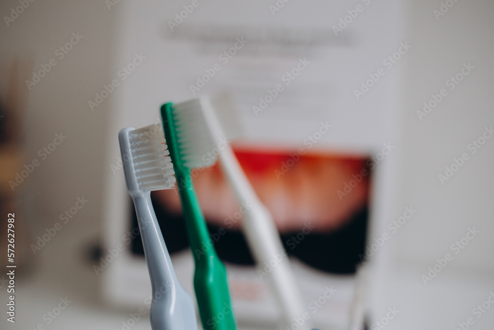 Toothbrushes in glass on blurred background in dental clinic