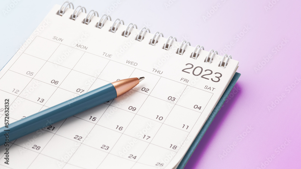 Calendar 2023 with blue pen on pink gradient background Calendar 2023 with blue pen on pink gradient background
