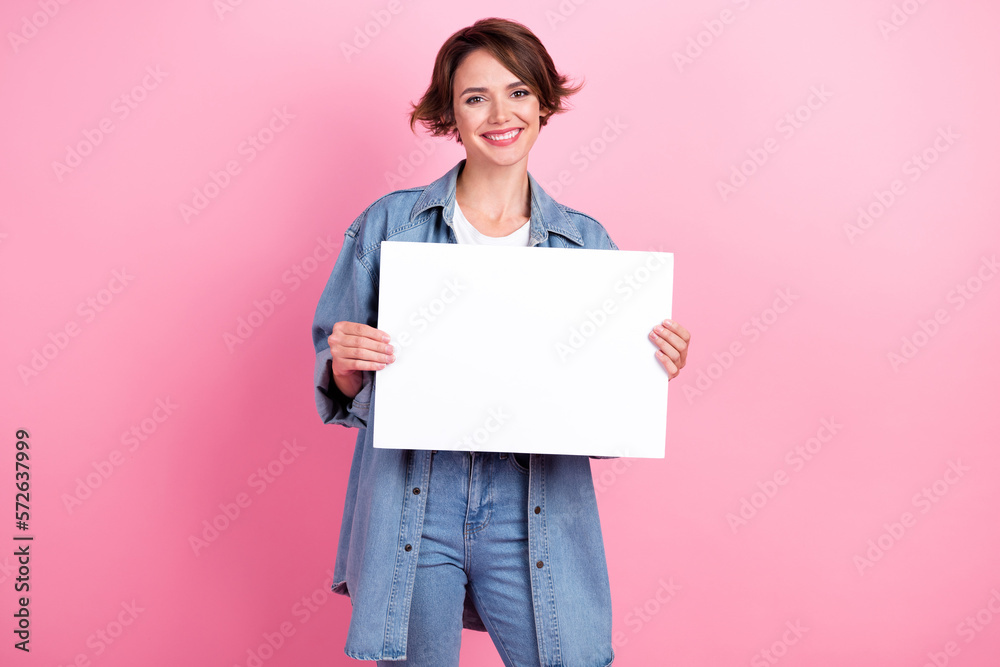 Photo of excited adorable lady dressed denim jacket rising white placard empty space isolated pink color background Photo of excited adorable lady dressed denim jacket rising white placard empty space isolated pink color background