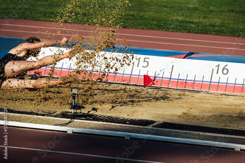 landing in sand male athlete triple jump