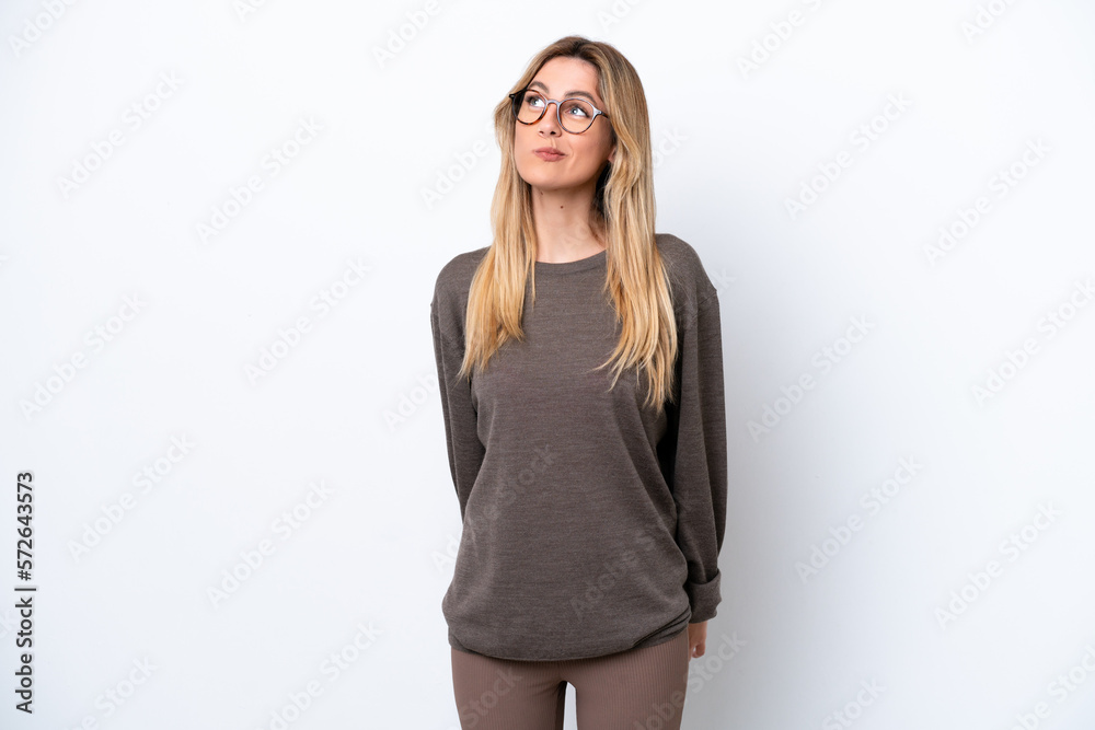 Young Uruguayan woman isolated on white background and looking up Young Uruguayan woman isolated on white background and looking up
