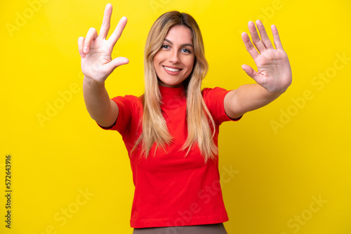 Young Uruguayan woman isolated on yellow background counting eight with fingers © luismolinero