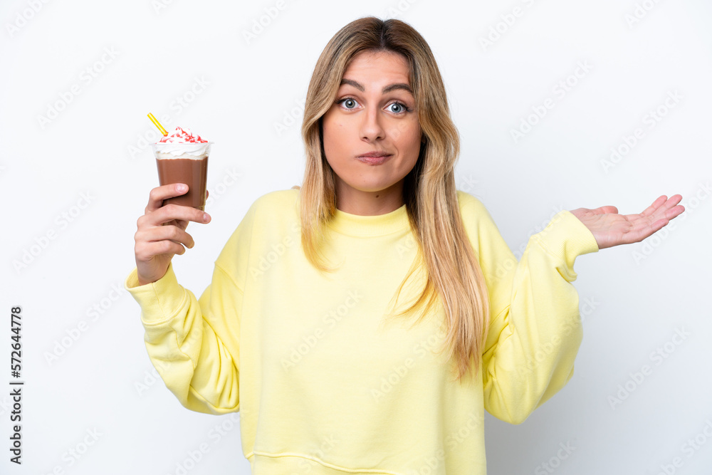Obraz premium Young Uruguayan woman holding Frappuccino isolated on white background having doubts while raising hands