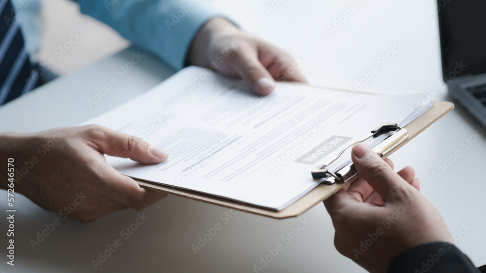 A person attends a job interview with a manager to join a company, he holds a resume and interview with information introducing himself and his ability to work. Job application concept. A person attends a job interview with a manager to join a company, he holds a resume and interview with information introducing himself and his ability to work. Job application concept.
