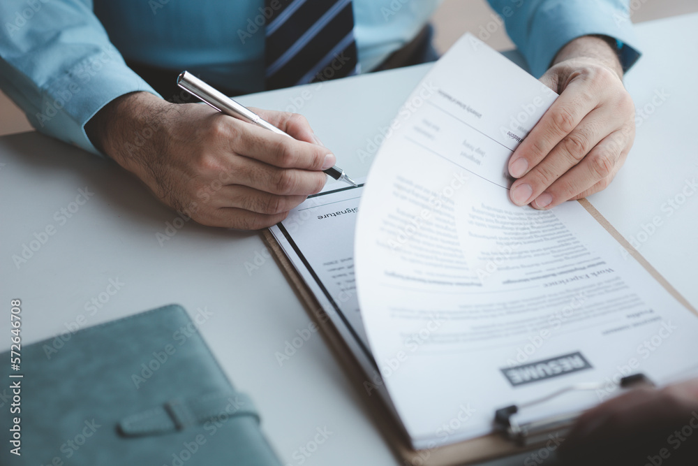 A person attends a job interview with a manager to join a company, he holds a resume and interview with information introducing himself and his ability to work. Job application concept. A person attends a job interview with a manager to join a company, he holds a resume and interview with information introducing himself and his ability to work. Job application concept.
