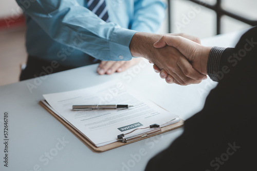 Photos A person attends a job interview with a manager to join a company, he holds a resume and interview with information introducing himself and his ability to work
