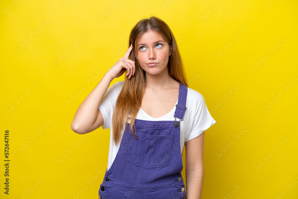 Young caucasian woman isolated on yellow background making the gesture of madness putting finger on the head Young caucasian woman isolated on yellow background making the gesture of madness putting finger on the head