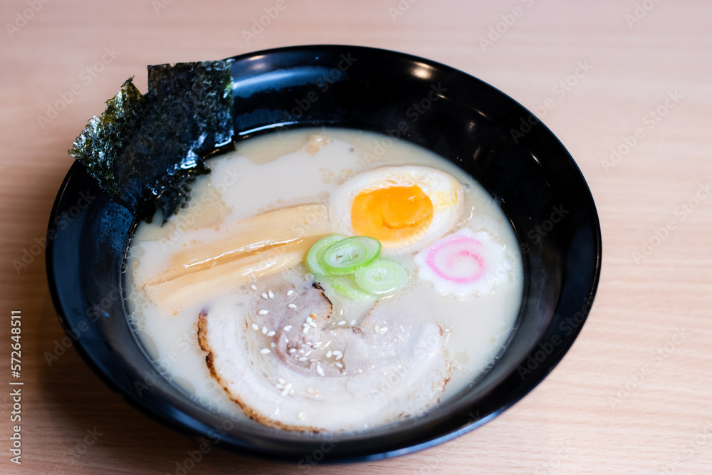 Stockfoto Tonkotsu ramen in a black cup topped with chashu pork, Naruto