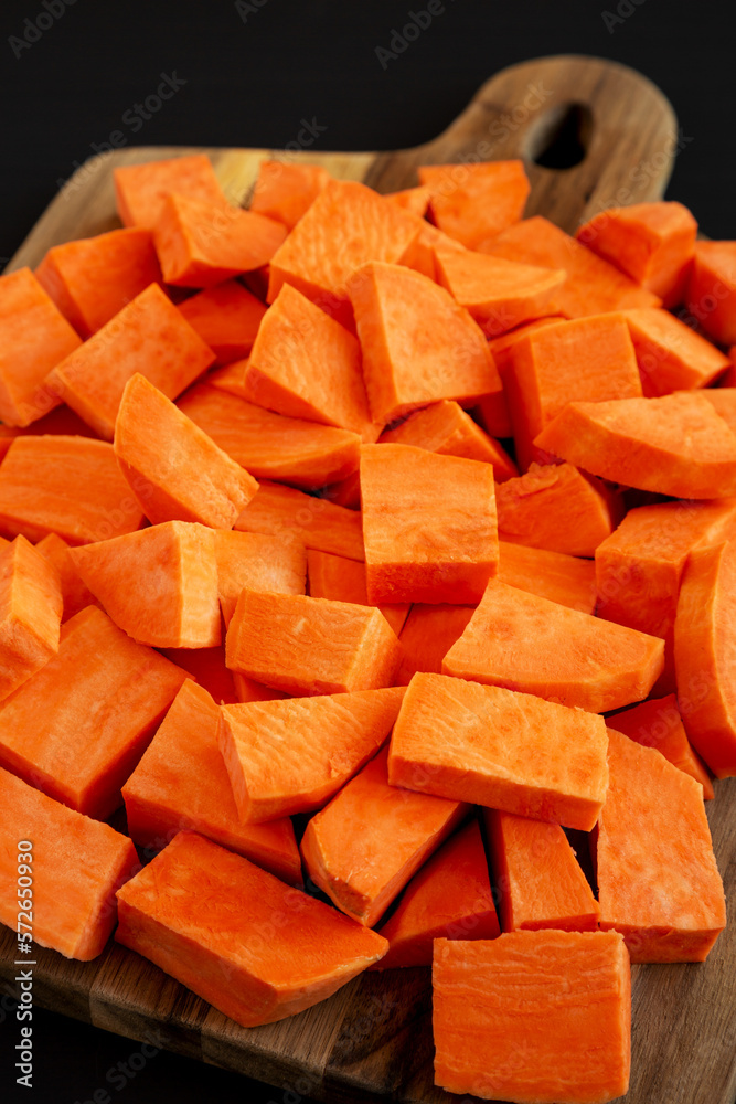 Raw Chopped Sweet Potatoes on a Cutting Board, low angle view. Raw Chopped Sweet Potatoes on a Cutting Board, low angle view.