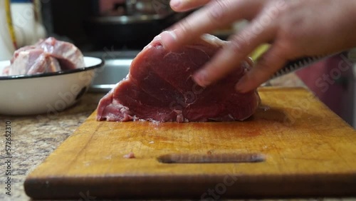 Rural cuisine. Cooking pork in a home country kitchen. Cut tenderloin for steak.