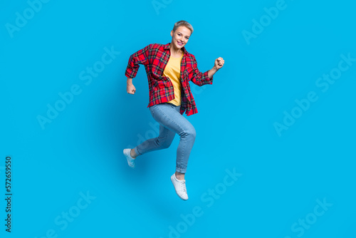 Full length photo of active pleasant good mood woman wear checkered shirt jeans running rush on sale isolated on blue color background