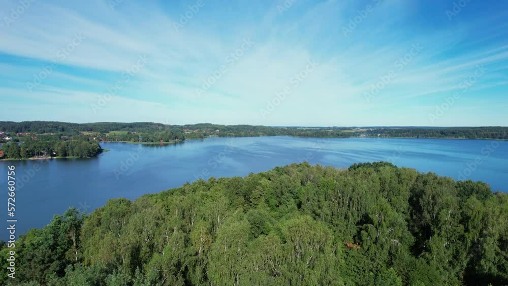 Majestic Aerial View of Calm Lake With Islands in Poland. Impressive Lake Houses. Village Houses on Shore of Paradise Lake. Peaceful Reflected on Water. Cottages Between Green Trees, Forest and Hills. Majestic Aerial View of Calm Lake With Islands in Poland. Impressive Lake Houses. Village Houses on Shore of Paradise Lake. Peaceful Reflected on Water. Cottages Between Green Trees, Forest and Hills.