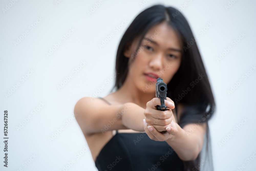 Sexy beauty young woman in black camisole posing with gun on white background. Girl in camisole with gun hand sexy brunette woman gun plain background. Sexy beauty young woman in black camisole posing with gun on white background. Girl in camisole with gun hand sexy brunette woman gun plain background.