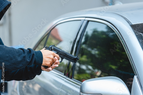Robber Thief Criminal Bandits striped with short gun rob Robber threaten woman in car and forced open Car door for car key. Seize car key and money of Victim © BESTIMAGE
