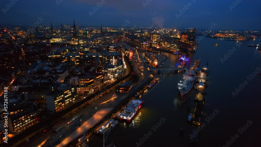 Aerial drone view of Hamburg at evening, Germany. Elbe coastline, moored boats, sea port, classic and modern buildings, roads with cars and nightlights Aerial drone view of Hamburg at evening, Germany. Elbe coastline, moored boats, sea port, classic and modern buildings, roads with cars and nightlights