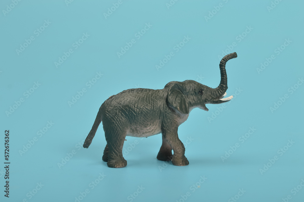 Black toy elephant isolated on a blue background.