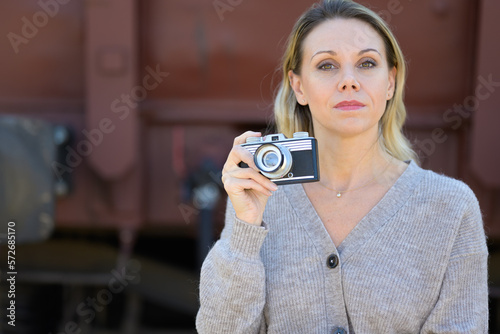 Serious middle aged woman with an old camera