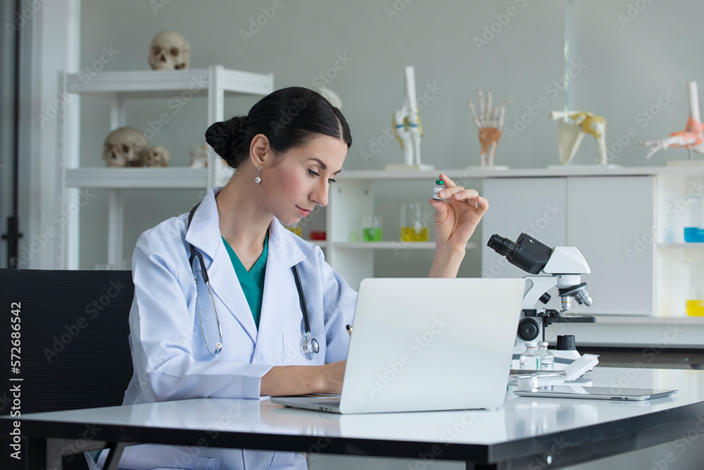 female scientist looking at the computer laptop in laboratory female scientist looking at the computer laptop in laboratory