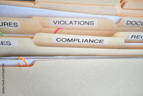 Compliance in the workplace. Folders labeled Compliance, Violations in focus. photo