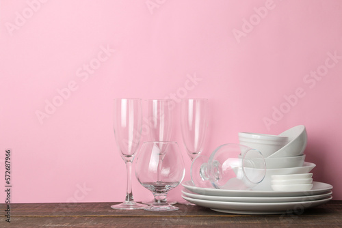 many different dishes. Dinnerware. on a pink background. utensils for table setting. various plates, bowls and cups.