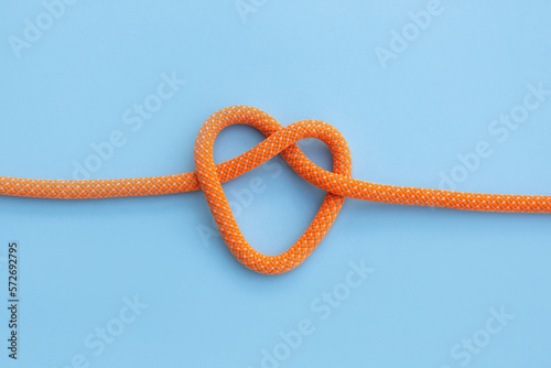 Rope with a heart shaped knot isolated on blue background