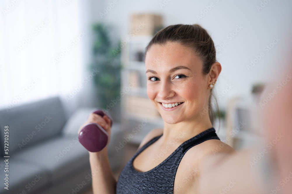 Young woman taking selfie while holding weight Young woman taking selfie while holding weight