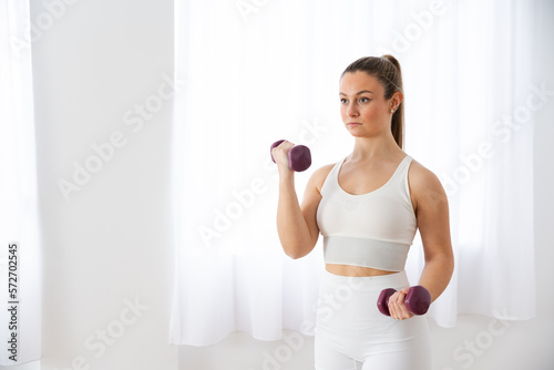 Young woman working out holding weights