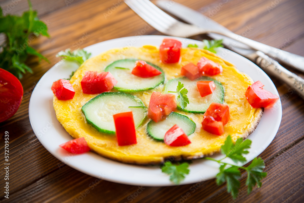 Fried omelet with zucchini, tomatoes, herbs in a plate Fried omelet with zucchini, tomatoes, herbs in a plate