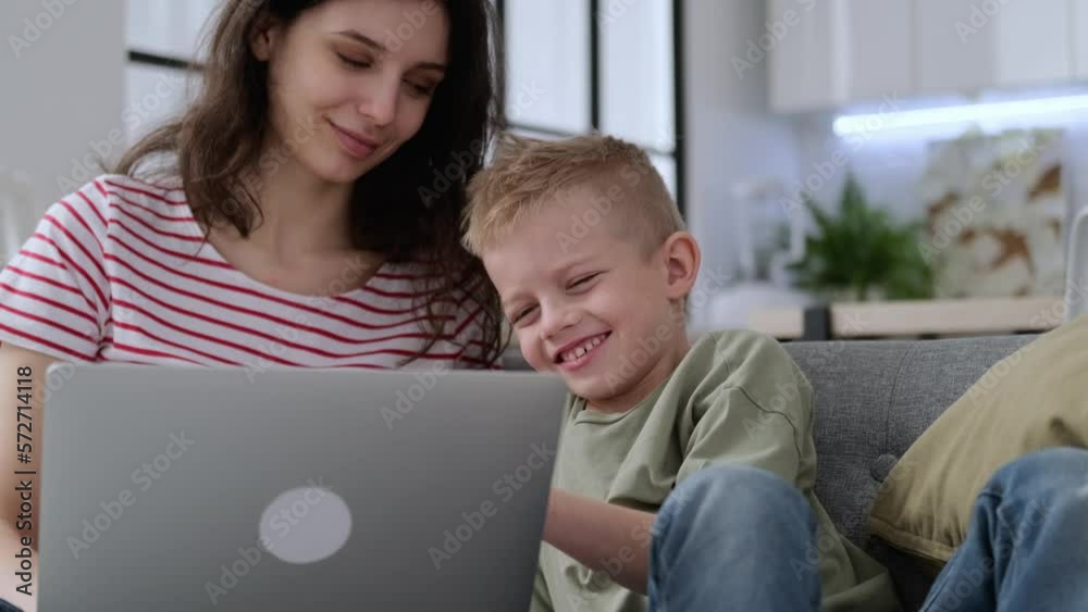 hard to Work mother remotely from home and family education, woman works on laptop, distracted by noisy son child having fun, jumping, running around sofa hard to Work mother remotely from home and family education, woman works on laptop, distracted by noisy son child having fun, jumping, running around sofa
