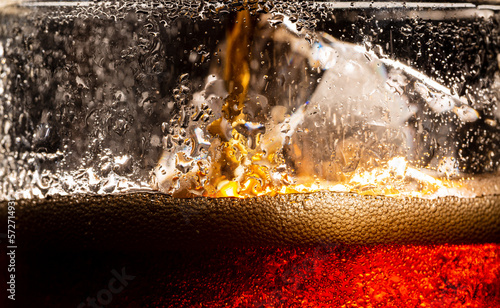 Macro cola and ice,Cola with Ice. Food background,Close up view of the ice cubes in cola background