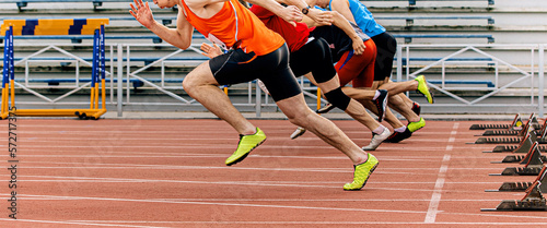 start sprint men runners run 100 meters at stadium