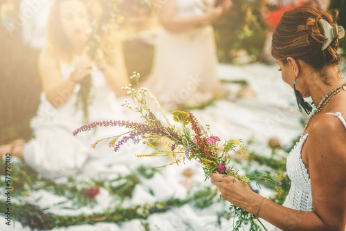 View of women making wreaths with beautiful flowers.