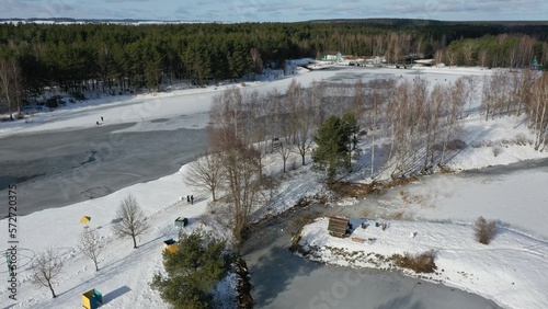 Hydropark in winter in the mountains under a layer of snow and ice. The system of river water channels in winter. Recreational recreation area in the forest. Summer beach covered with snow.