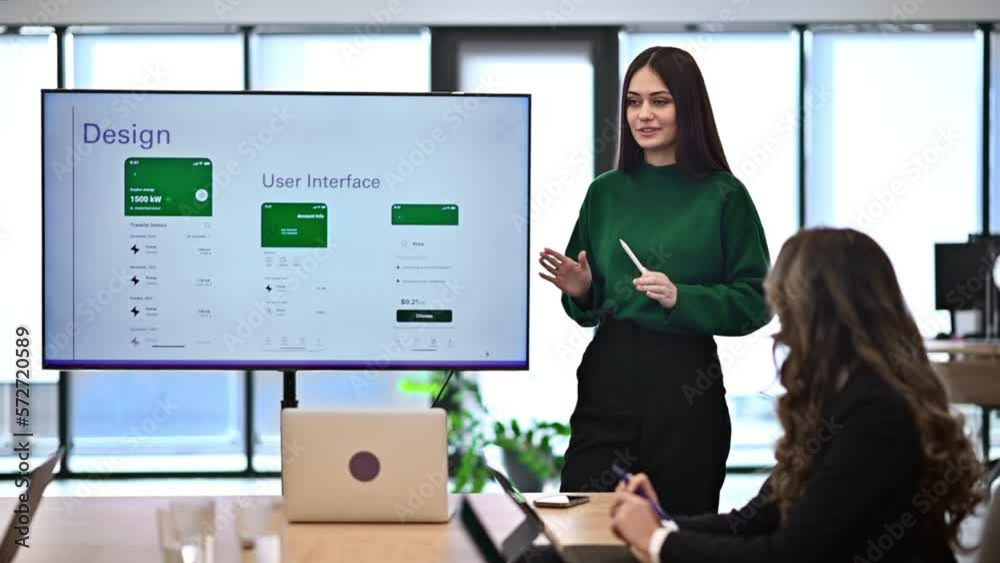 Female worker leading business meeting in an office, discussing business affairs with other workers using a big display with info. Slow motion Female worker leading business meeting in an office, discussing business affairs with other workers using a big display with info. Slow motion