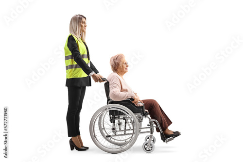 Special assitance worker standing behind a senior woman in a wheelchair photo