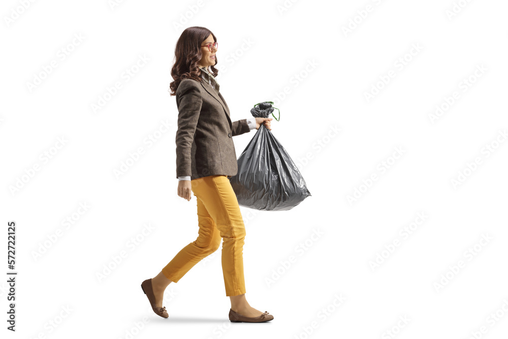 Φωτογραφία Full length profile shot of a young woman in formal clothes carrying a plastic w