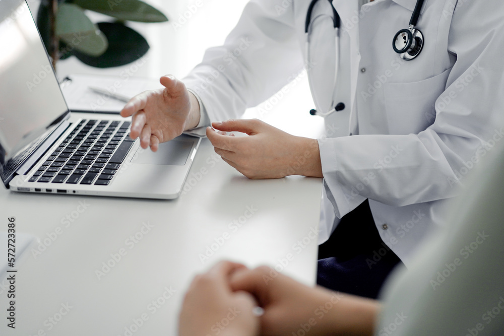 Doctor and patient discussing current health examination while sitting at the desk in clinic office, closeup. Perfect medical service and medicine concept Doctor and patient discussing current health examination while sitting at the desk in clinic office, closeup. Perfect medical service and medicine concept