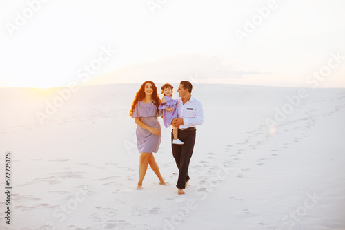 Family at sand dunes in most big sand desert in the world at sunset